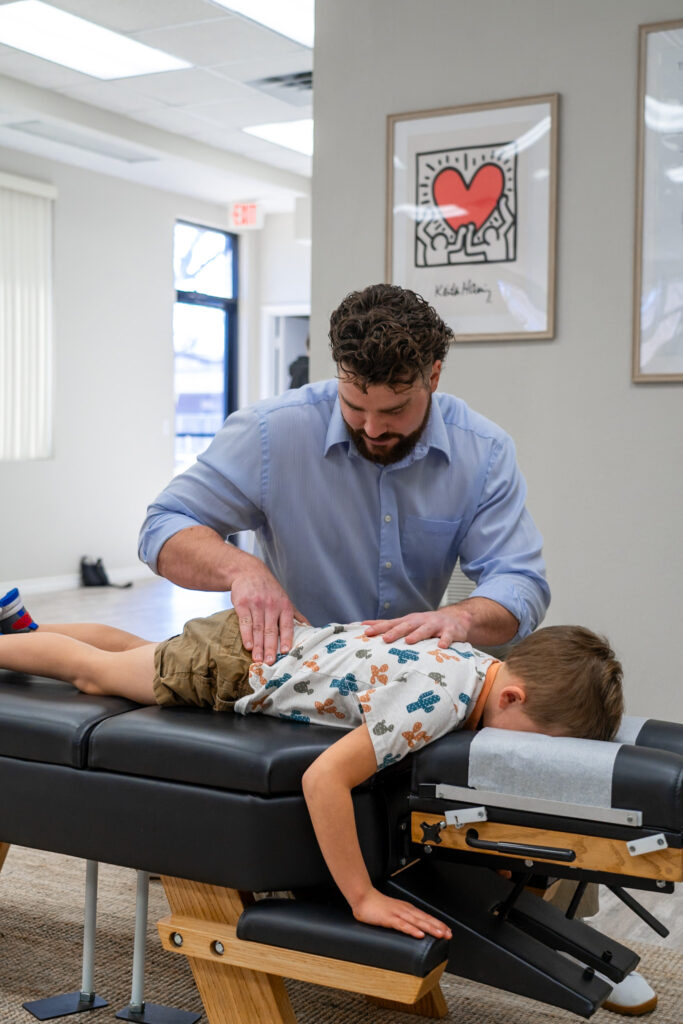 Dr. Korrin providing gentle pediatric chiropractic care to young child at Vita Nova Chiropractic Plano