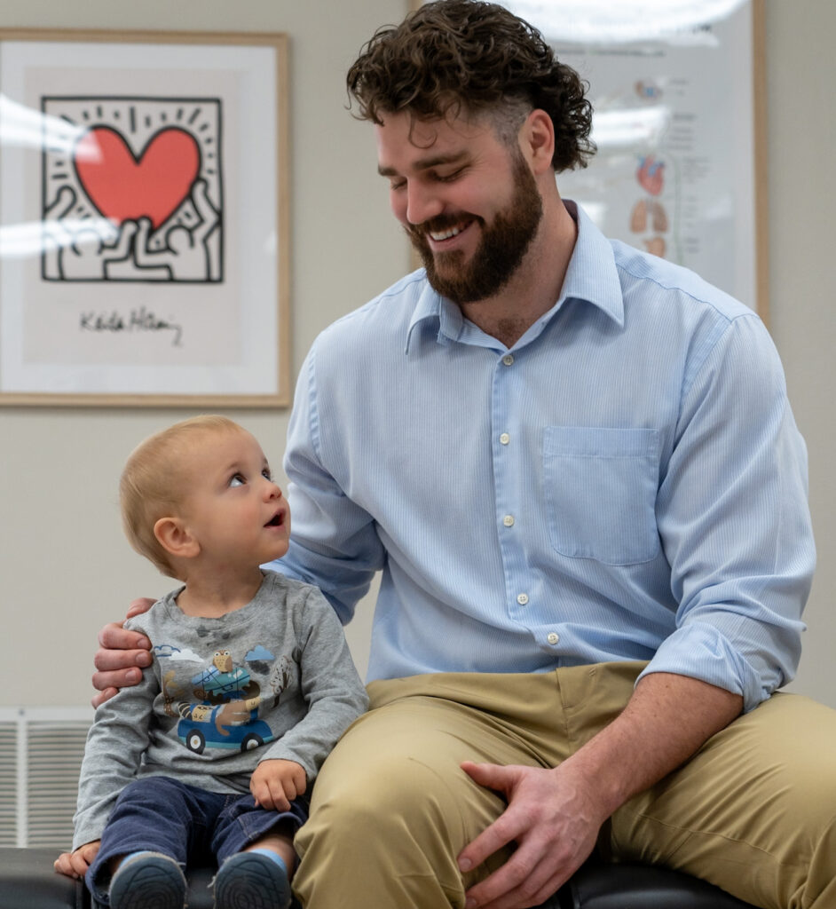 Dr. Korrin Taylor smiling with a young patient at Vita Nova Chiropractic