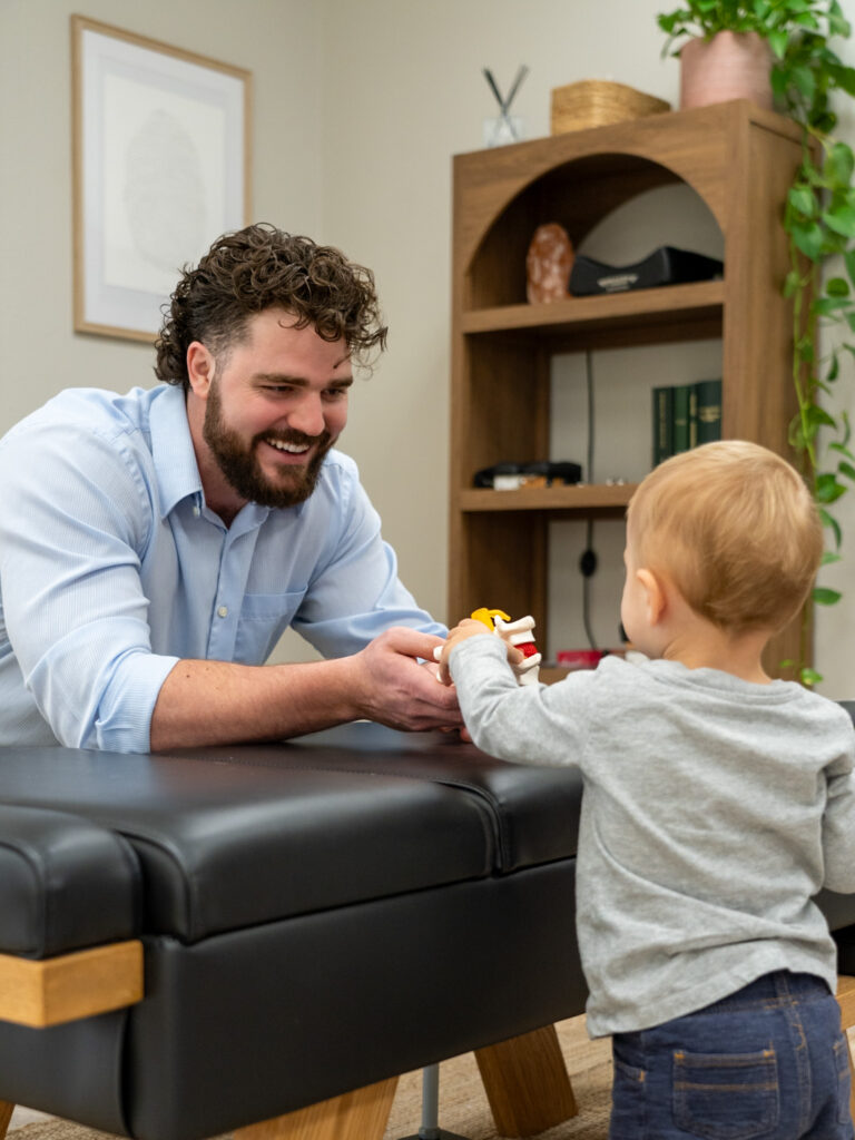 Family chiropractor in Plano TX providing gentle chiropractic adjustment for a child to support healthy growth and nervous system balance