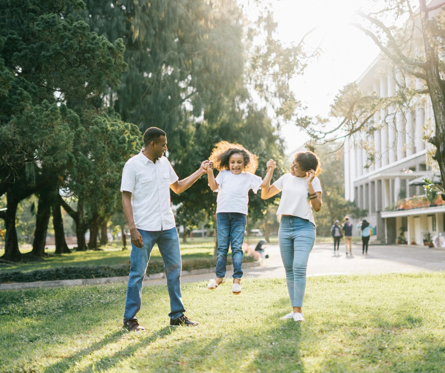 Happy family playing with child outdoors on a sunny day
