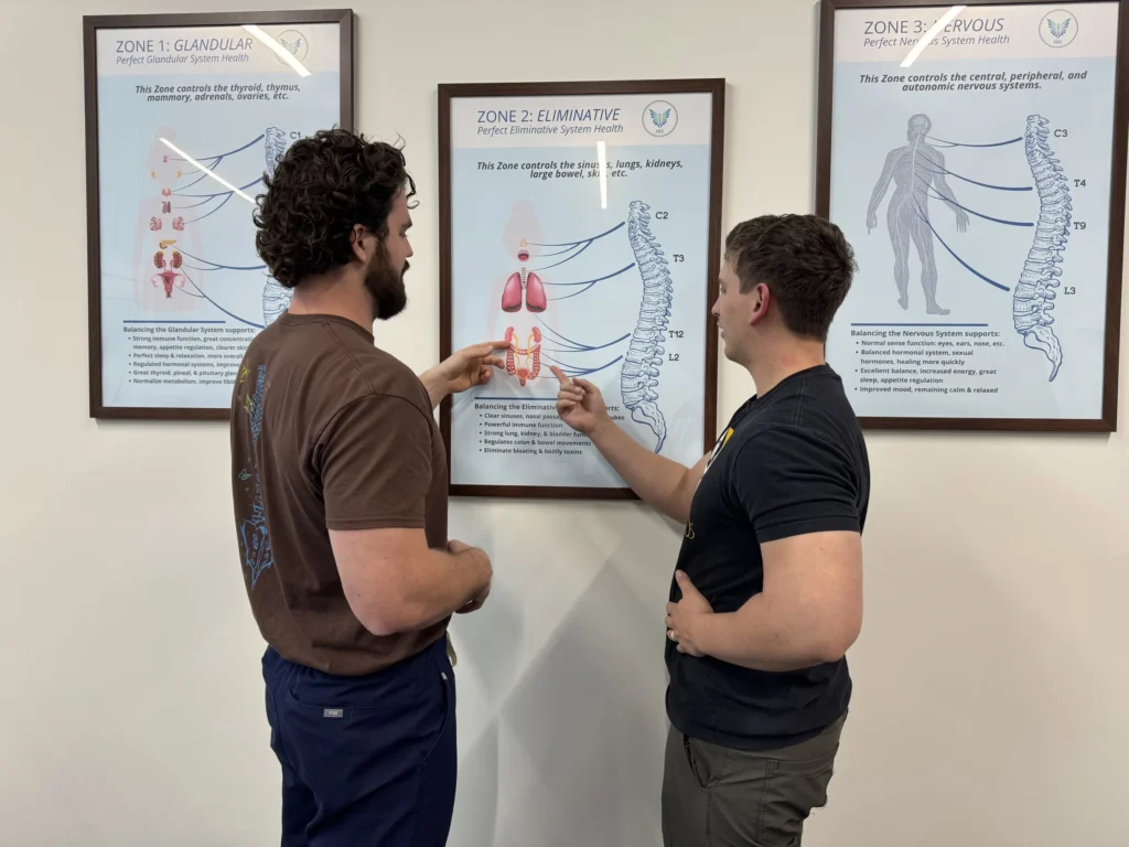 Dr. Korrin Taylor points to an anatomical Zone Technique chart while talking with a patient.